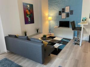 ein Wohnzimmer mit einer blauen Couch und einem Fernseher in der Unterkunft FlatDeCologne - Sommer in der Stadt- City Apartment Nähe DOM in Köln