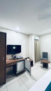 ein Zimmer mit einem Schreibtisch mit Fernseher und einem Stuhl in der Unterkunft Kaloor Residency in Ernakulam