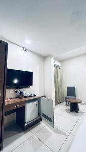 ein Zimmer mit einem Schreibtisch mit Fernseher und einem Stuhl in der Unterkunft Kaloor Residency in Ernakulam