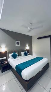 ein Schlafzimmer mit einem großen Bett und blauen Kissen in der Unterkunft Kaloor Residency in Ernakulam + 4 Fotos