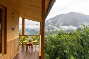 a porch of a house with a view of a mountain at The nature view A shape tree cottage in Banjār