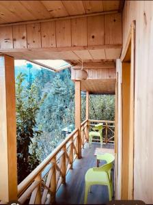 a balcony of a house with chairs and a table at The nature view A shape tree cottage in Banjār