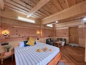 a bedroom with a large bed in a wooden room at The nature view A shape tree cottage in Banjār