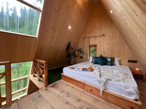 a bedroom with a bed in a wooden cabin at The nature view A shape tree cottage in Banjār +12 photos