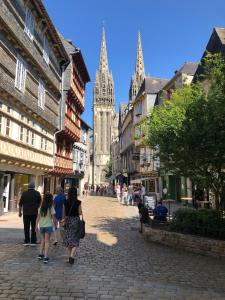 a group of people walking down a street with a cathedral at Ty Kéréon - Le cocon urbain in Quimper