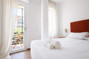 ein weißes Schlafzimmer mit einem Bett mit Handtüchern darauf in der Unterkunft Maison Hermes in Mailand