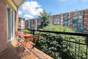 ein Balkon mit Tisch und Stühlen und ein Gebäude in der Unterkunft Maison Hermes in Mailand