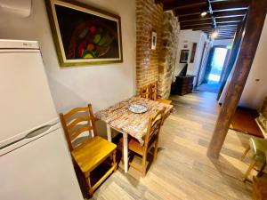 a table and chairs in a room with a refrigerator at Casa Pueblo Anibal in Fermoselle