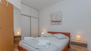 een slaapkamer met een wit bed met 2 kussens bij Villa Radic - Makarska by Villas Guide in Baška Voda