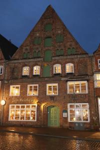 a large brick building with lights in the windows at Momento Heidkrug in Lüneburg