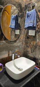 a bathroom with a white sink and a mirror at Amrutvel Resort in Pune