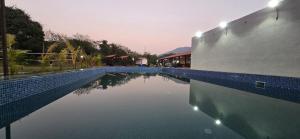 a pool of water next to a building at Amrutvel Resort in Pune