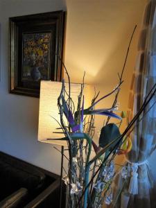 un vaso con dei fiori accanto a una lampada di The Blue Park By OSCAR a Manāli