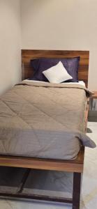 a bed with a wooden headboard and pillows on it at Amrutvel Resort in Pune