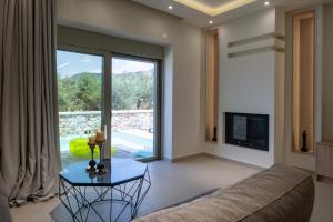 a living room with a couch and a tv at Pasithea Villas in Neokhórion
