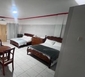 a hotel room with two beds and a chair at Residencial NUBE 69 in Isla del Mono