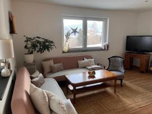 un soggiorno con un divano e un tavolo di Ferienwohnung Mauerblümchen a Dornbach