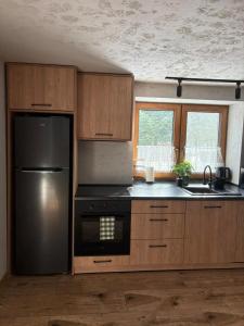 a kitchen with a black refrigerator and a sink at Przystanek Stodoła in Rajcza