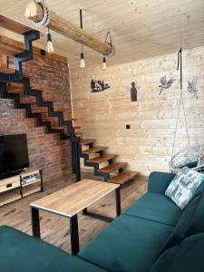a living room with a blue couch and a staircase at Przystanek Stodoła in Rajcza