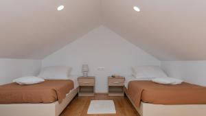 twee bedden in een kamer met witte muren en houten vloeren bij Villa Primabella -Makarska by Villas Guide in Poljica +19 foto's