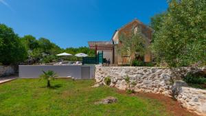 een huis met een stenen muur en een tuin bij Villa Primabella -Makarska by Villas Guide in Poljica