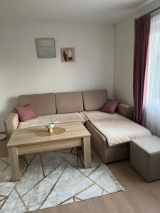 een woonkamer met een bank en een salontafel bij Apartman Mila Prnjavor in Prnjavor