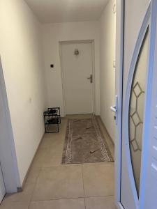 een lege hal met een witte deur en een tapijt bij Apartman Mila Prnjavor in Prnjavor