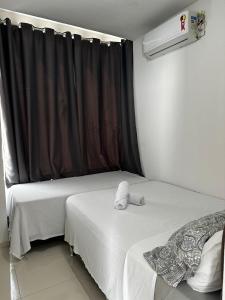 two beds in a room with a window at AP Brisa do Rio in Galinhos +10 photos