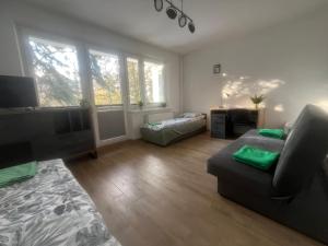 a living room with a couch and a flat screen tv at Pokoje Metro Imielin in Warsaw +4 photos
