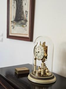 een klok onder een glazen stolp op een tafel bij A Casa do Comandante - Piscina e Jardim in Lagoa +33 foto's