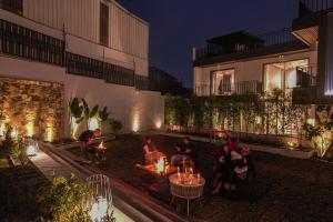 a group of people sitting in a courtyard at night at SaffronStays Boudhi Tree Villas in Rishīkesh