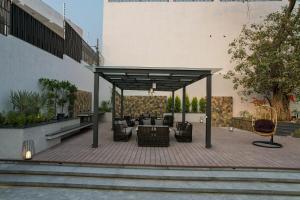 a patio with chairs and tables on a building at SaffronStays Boudhi Tree Villas in Rishīkesh