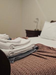 een stapel handdoeken bovenop een bed bij A Casa do Comandante - Piscina e Jardim in Lagoa