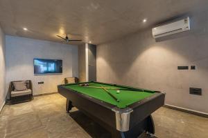 a billiard room with a pool table and a room with avertisement at SaffronStays Boudhi Tree Villas in Rishīkesh
