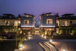 a building with lights in front of it at night at SaffronStays Boudhi Tree Villas in Rishīkesh