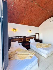 two beds in a room with a red ceiling at palma beach camp nuwibae in Nuweiba +22 photos