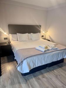 een slaapkamer met een groot bed met witte lakens en kussens bij Apartamento Tahoro in La Orotava