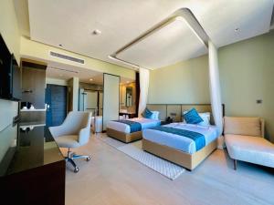 een slaapkamer met twee bedden, een bureau en een stoel bij Matemwe Sands Hotel in Mkuyuni Pwani +61 foto's