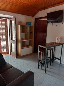 a living room with a table and a kitchen at Apartmani Vidović Viganj in Viganj