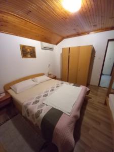 a bedroom with a bed and a wooden ceiling at Apartmani Vidović Viganj in Viganj