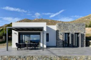 a house with a table and chairs on a patio at KYAN Syros in Liaropá
