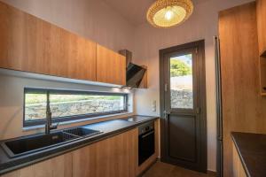a small kitchen with a sink and a window at KYAN Syros in Liaropá