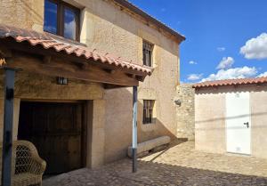 a building with a garage with a white door at Casa La Fuencisla in Castiltierra