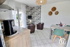a kitchen with a tv and a table and chairs at Brin de bonheur in Évran