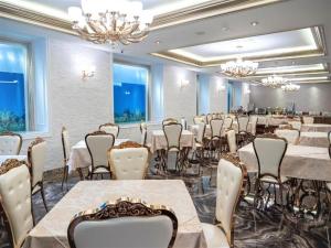a banquet room with tables and chairs and chandeliers at HOTEL BOCA Center in Tirana