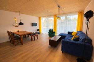 a living room with a blue couch and a table at Ankerix & Deichfix in Büsum