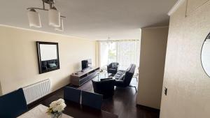 een woonkamer met een bank en een televisie bij Viña del Mar - Parque Marina in Viña del Mar