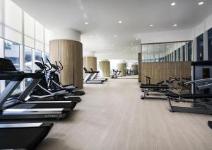 a gym with several treadmills and cardio machines at UHF HOTELS and RESORTS PINETREE in Iskandar Puteri