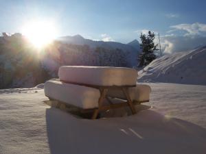 een bank bedekt met sneeuw met de zon op de achtergrond bij Gite Le Croé in La Celle-sous-Gouzon