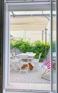 a patio with a white table and chairs at Lupicante 56 Cesenatico in Cesenatico +62 photos